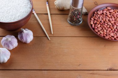 Çeşitli Asya vejetaryen yemek malzemeler. Kuruyemiş, sebze, zencefil kökü. Taze yeşillik, dereotu ve maydanoz. Pirinç, fıstık ve baharat ahşap arka plan üzerinde. Uzay kopyalayın. Çin yemek çubukları