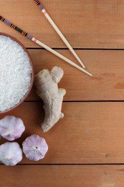 Çeşitli Asya vejetaryen yemek malzemeler. Kuruyemiş, sebze, zencefil kökü. Taze yeşillik, dereotu ve maydanoz. Pirinç, fıstık ve baharat ahşap arka plan üzerinde. Uzay kopyalayın. Çin yemek çubukları