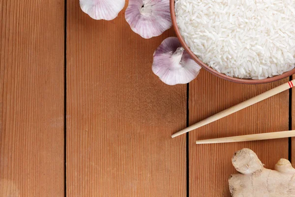 Çeşitli Asya vejetaryen yemek malzemeler. Kuruyemiş, sebze, zencefil kökü. Taze yeşillik, dereotu ve maydanoz. Pirinç, fıstık ve baharat ahşap arka plan üzerinde. Uzay kopyalayın. Çin yemek çubukları