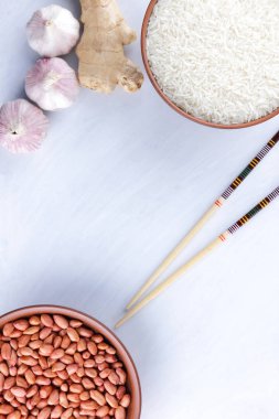 Çeşitli Asya vejetaryen yemek malzemeler. Kuruyemiş, sebze, zencefil kökü. Taze yeşillik, dereotu ve maydanoz. Pirinç, fıstık ve baharat beyaz zemin üzerinde. Uzay kopyalayın. Sanat