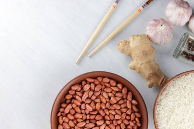 Çeşitli Asya vejetaryen yemek malzemeler. Kuruyemiş, sebze, zencefil kökü. Taze yeşillik, dereotu ve maydanoz. Pirinç, fıstık ve baharat beyaz zemin üzerinde. Uzay kopyalayın. Sanat