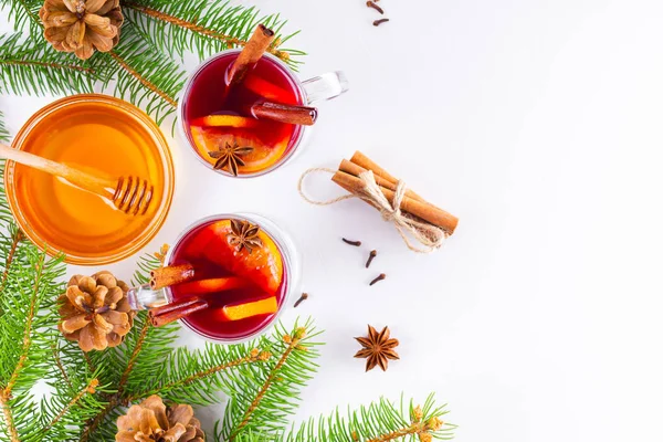 Mulled wine in glass mug with spices. Glasses of mulled wine with cinnamon, anise and fir tree branches. Winter Christmas drink. Top view. Flat lay