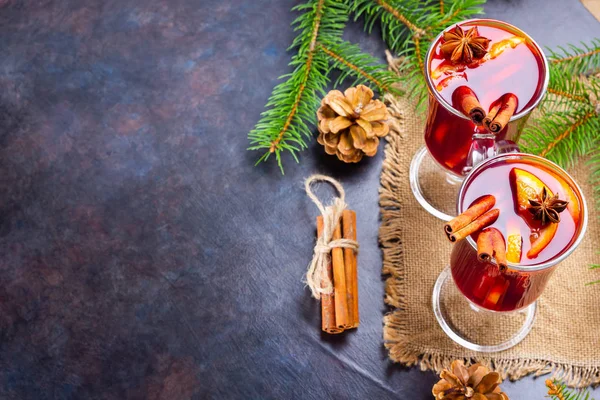 Mulled wine in glass mug with spices. Glasses of mulled wine with cinnamon, anise and fir tree branches. Winter Christmas drink. Top view