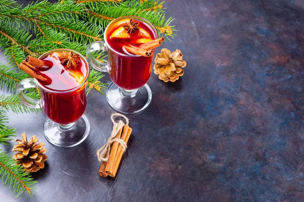 Mulled wine in glass mug with spices. Glasses of mulled wine with cinnamon, anise and fir tree branches. Winter Christmas drink. Top view