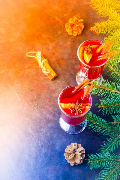 Mulled wine in glass mug with spices. Glasses of mulled wine with cinnamon, anise and fir tree branches. Winter Christmas drink. Top view
