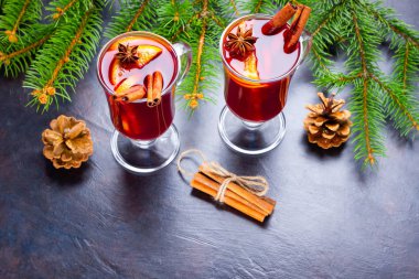 Baharatlı cam bardakta sıcak şarap. Tarçın, anason ve köknar dallı sıcak şarap kadehleri. Kış Noel içkisi. Üst görünüm