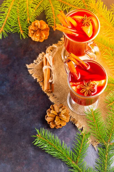 Mulled wine in glass mug with spices. Glasses of mulled wine with cinnamon, anise and fir tree branches. Winter Christmas drink. Top view