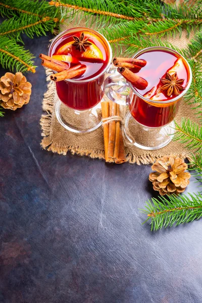 Mulled wine in glass mug with spices. Glasses of mulled wine with cinnamon, anise and fir tree branches. Winter Christmas drink. Top view