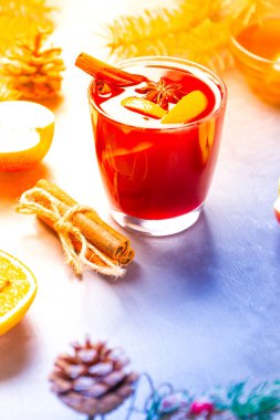 Bardakta baharatlı sıcak şarap. Tarçınlı kırmızı şarap, anason ve bal. Çam kozalakları ve köknar dalları ile çimento gri arka planda sıcak sıcak sıcak şarap