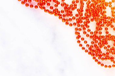 Mermer arka planda kırmızı noel boncukları. Noel aralığı. Beyaz arka planda kırmızı boncuk çizgisi. Üst Manzara. Boşluğu kopyala