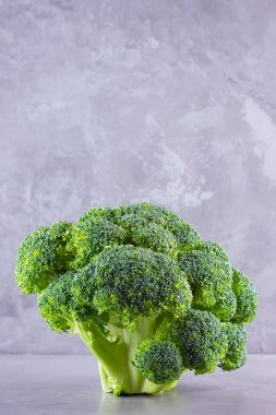 Çimento arka planında brokoli. Kopya alanı olan taze brokoli. Sağlıklı yeşil yiyecekler. Vejetaryen yemeği. Minimalizm