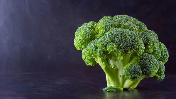 Broccoli on a dark background. Fresh broccoli with copy space. Healthy green food clean eating. Vegetarian food. Minimalism