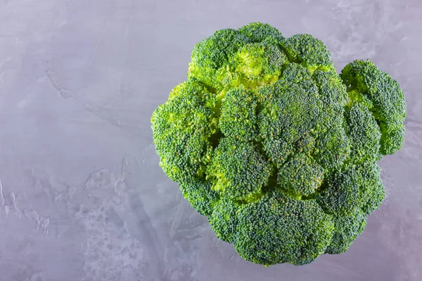Broccoli on cement background. Fresh broccoli with copy space. Healthy green food eating. Vegetarian food. Minimalism