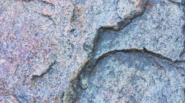 Texture of granite. Granite rock with reddish color. Background from solid stone. Pattern with natural material. Widescreen