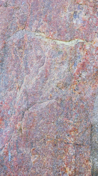 Texture of granite. Granite rock with reddish color. Background from solid stone. Pattern with natural material. Widescreen
