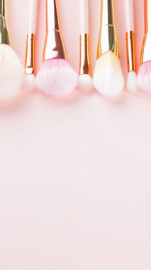 Pembe arka planda makyaj fırçaları. Altın makyaj fırçası seti, konsept. Pastel renkte kadın güzellik aksesuarı. Uzayı kopyala Geniş Ekran