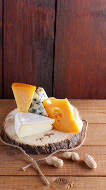 Tahta tahtalarda çeşitli peynir, armut ve fıstık çeşitleri. Camembert peyniri, sert sarı peynir, ahşap arka planda Dorblu. Süt ürünleri, armut ve fındık. Geniş Ekran