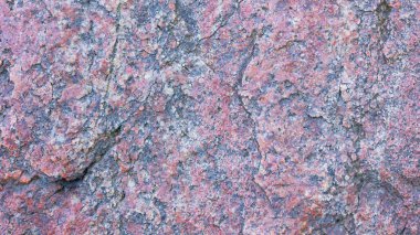 Granit dokusu. Kırmızımsı renkte granit kaya. Katı taştan yapılmış arka plan. Doğal malzemeli desen. Geniş Ekran