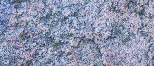 Granite texture. Granite rocks with porous surface. Background from solid stone. Pattern with natural material. Widescreen