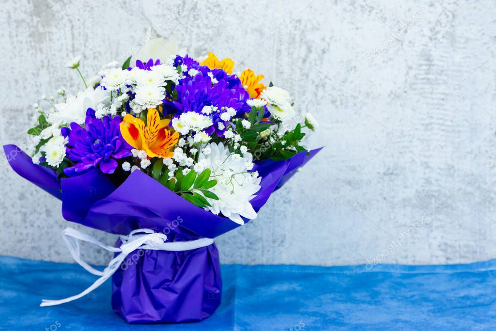 Bouquet of wildflowers on Valentine's Day. Bunch of alstroemeria flowers in the classic blue wrapper. Festive bouquet of flowers with copy space
