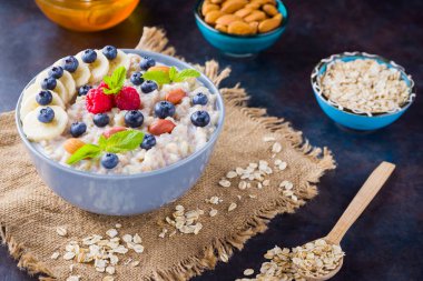 Böğürtlenli yulaf lapası, meyve ve bal. Yulaf ezmesi, ahududu, yabanmersini ve badem ve çuval bezi. Sağlıklı kahvaltı.