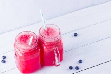 Karpuz dilimleri ile mason kavanozlarda karpuz içmek. Beyaz arka planda karpuz smoothies ve yaban mersini. Vejetaryen için yaz sağlıklı içecek. Kopyalama alanı