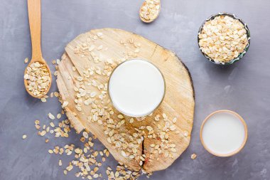 Yulaf sütü. Tahta tezgahta organik yulaf sütü. Sağlıklı vejetaryen sütsüz organik içecek ve yulaf lapası. Beton arka planda sağlıklı bir süt. Sıfır atık