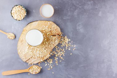 Yulaf sütü. Tahta tezgahta organik yulaf sütü. Sağlıklı vejetaryen sütsüz organik içecek ve yulaf lapası. Beton arka planda sağlıklı bir süt. Sıfır atık