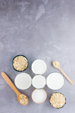 Yulaf sütü kavramı. Tahta tezgahta organik yulaf sütü. Vegan sütsüz alternatif süt. Beton arka planda sağlıklı vejetaryen sütü. Sıfır kayıp. Üst Manzara. Düz yatıyordu