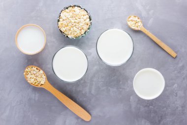 Yulaf sütü kavramı. Tahta tezgahta organik yulaf sütü. Vegan sütsüz alternatif süt. Beton arka planda sağlıklı vejetaryen sütü. Sıfır kayıp. Üst Manzara. Düz yatıyordu