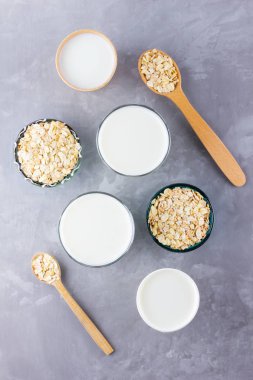 Yulaf sütü kavramı. Tahta tezgahta organik yulaf sütü. Vegan sütsüz alternatif süt. Beton arka planda sağlıklı vejetaryen sütü. Sıfır kayıp. Üst Manzara. Düz yatıyordu