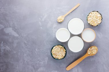 Yulaf sütü kavramı. Tahta tezgahta organik yulaf sütü. Vegan sütsüz alternatif süt. Beton arka planda sağlıklı vejetaryen sütü. Sıfır kayıp. Üst Manzara. Düz yatıyordu