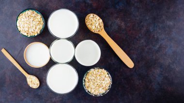 Yulaf sütü. Siyah arka planda organik yulaf sütü. Vegan sütsüz alternatif süt. Siyah arka planda sağlıklı vejetaryen sütü. Üst görünüm