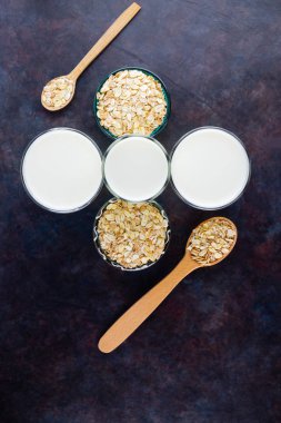 Yulaf sütü. Siyah arka planda organik yulaf sütü. Vegan sütsüz alternatif süt. Siyah arka planda sağlıklı vejetaryen sütü. Üst görünüm