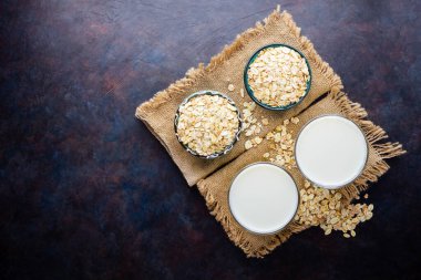 Yulaf sütü. Siyah arka planda organik yulaf sütü. Vegan sütsüz alternatif süt. Sağlıklı vejetaryen sütü. Üst Manzara. Düz yatıyordu