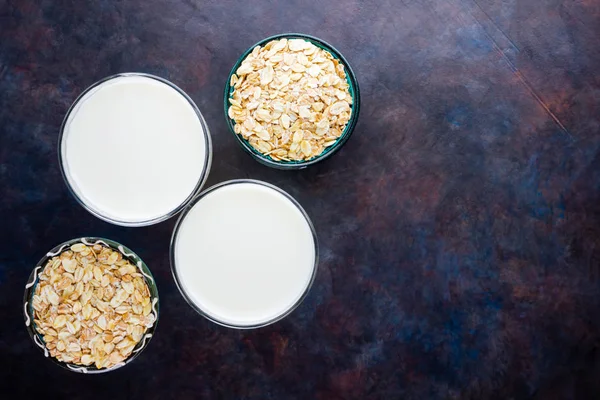 Oat milk. Organic oat milk on a dark background. Vegan non dairy alternative milk. Healthy vegan milk on black background. Top view. Flat lay