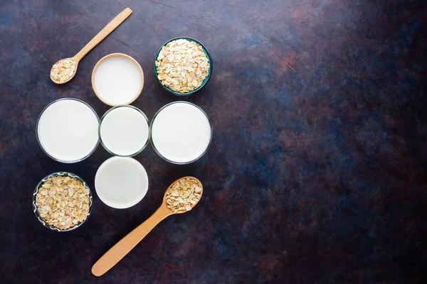 Oat milk. Organic oat milk on a dark background. Vegan non dairy alternative milk. Healthy vegan milk on black background. Top view