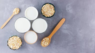 Yulaf sütü kavramı. Tahta tezgahta organik yulaf sütü. Vegan sütsüz alternatif süt. Beton arka planda sağlıklı vejetaryen sütü. Sıfır kayıp. Üst Manzara. Düz yatıyordu