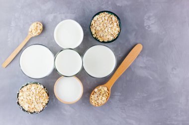 Yulaf sütü kavramı. Tahta tezgahta organik yulaf sütü. Vegan sütsüz alternatif süt. Beton arka planda sağlıklı vejetaryen sütü. Sıfır kayıp. Üst Manzara. Düz yatıyordu