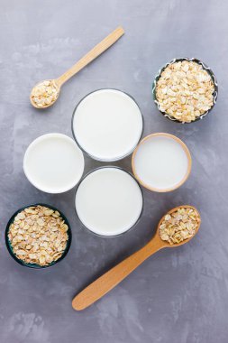 Yulaf sütü kavramı. Tahta tezgahta organik yulaf sütü. Vegan sütsüz alternatif süt. Beton arka planda sağlıklı vejetaryen sütü. Sıfır kayıp. Üst Manzara. Düz yatıyordu