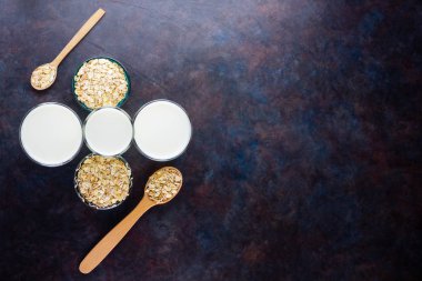Yulaf sütü. Siyah arka planda organik yulaf sütü. Vegan sütsüz alternatif süt. Siyah arka planda sağlıklı vejetaryen sütü. Üst görünüm