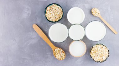 Yulaf sütü kavramı. Tahta tezgahta organik yulaf sütü. Vegan sütsüz alternatif süt. Beton arka planda sağlıklı vejetaryen sütü. Sıfır kayıp. Üst Manzara. Düz yatıyordu