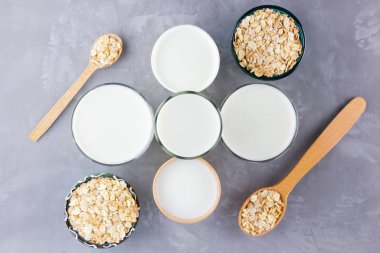 Yulaf sütü kavramı. Tahta tezgahta organik yulaf sütü. Vegan sütsüz alternatif süt. Beton arka planda sağlıklı vejetaryen sütü. Sıfır kayıp. Üst Manzara. Düz yatıyordu