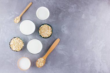 Yulaf sütü kavramı. Tahta tezgahta organik yulaf sütü. Vegan sütsüz alternatif süt. Beton arka planda sağlıklı vejetaryen sütü. Sıfır kayıp. Üst Manzara. Düz yatıyordu