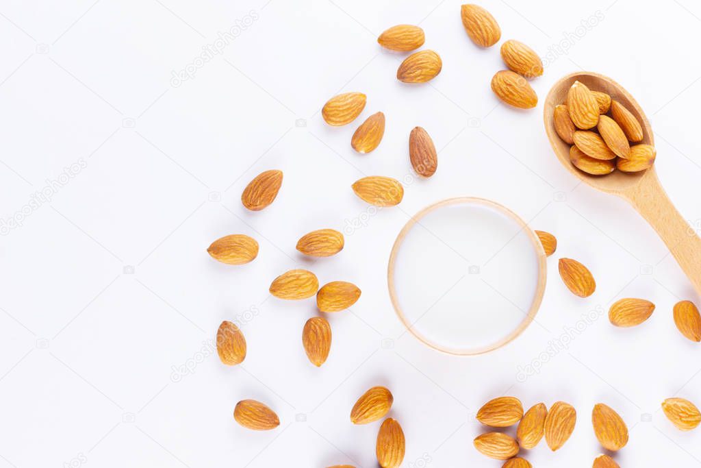 Almond milk with almond on white background. Homemade organic almond milk in a paper cup for healthy breakfast. Vegan milk from almonds nuts in kraft paper cup. Alternative milk. Zero waste