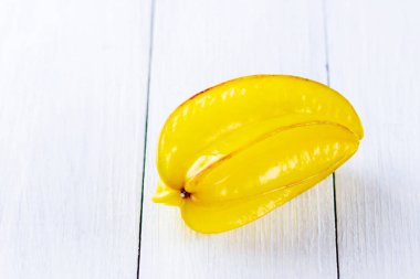 Beyaz tahtalarda Carambola. Beyaz arka planda Star Fruit (Averrhoa carambola L.). Tahtada sarı meyveli karambola