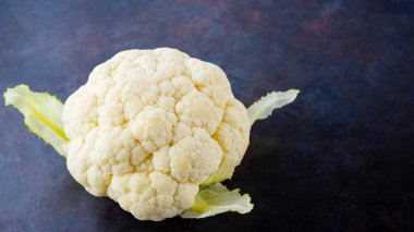 Karanlık arka planda karnabahar. Siyah arka planda organik karnabahar. Vejetaryen sağlıklı yemek. Minimalizm