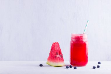 Karpuz dilimleri ile mason kavanozlarda karpuz içmek. Beyaz arka planda karpuz smoothies ve yaban mersini. Vejetaryen için yaz sağlıklı içecek. Kopyalama alanı