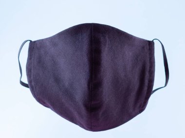 El yapımı koruyucu maske. Pamuktan yapılmış antivirüs maskesi. Salgın bir virüs olan COVID-19 sırasında siyah stil bir yüz maskesi. Mavi arka planda yüz koruyucu maskesi