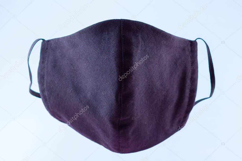 Protective mask. Antivirus mask made from cotton. Black face mask during a pandemic virus COVID-19. Face protective mask on a blue background